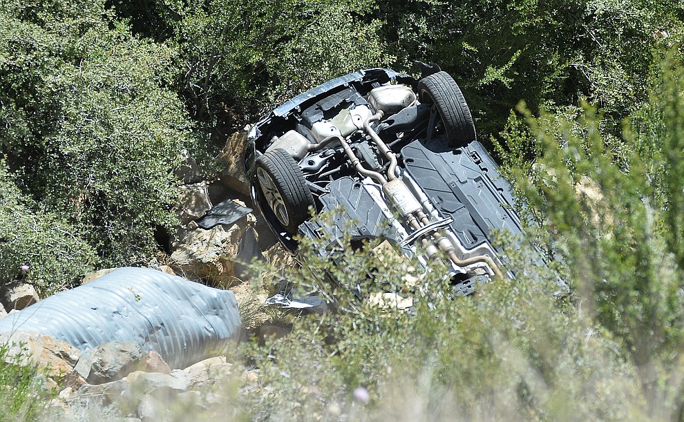 Arizona Department of Public Safety (DPS) investigators are on the scene where a stolen vehicle was run off a cliff at mile marker 303 on Highway 89 Monday, May 28 between Prescott and Wilhoit. The vehicle is approximately 500 feet down a steep hillside, landing in a drainage. (Les Stukenberg/Courier)