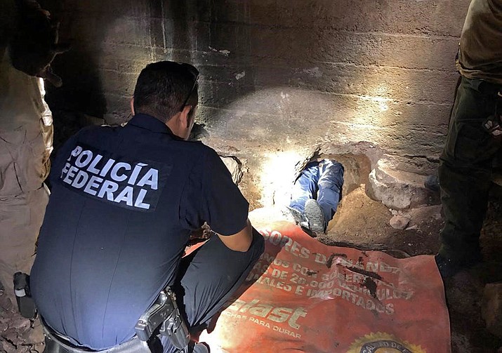 Mexican Federal Police officers examine the Nogales-Sonora, Mexico, entrance to an incomplete cross-border tunnel leading to a parking lot in Nogale. The Border Patrol said Friday, May 31, that the tunnel found Wednesday was connected to a storm drain that runs into the United States from Mexico. (U.S. Customs and Border Protection via AP)