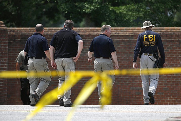 Law enforcement officials walk down a ramp to enter a municipal building that was the scene of a shooting, Sunday, June 2, 2019, in Virginia Beach, Va. DeWayne Craddock, a longtime city employee, opened fire at the building Friday before police shot and killed him, authorities said. (Patrick Semansky/AP)