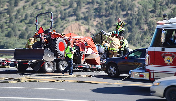 Emergency personnel try to free a victim trapped in her car after a trailer came unhitched and collided head-on with her car on Highway 69 at Mendecino Drive in Prescott Valley Friday, June 7, 2019. (Les Stukenberg/Courier)