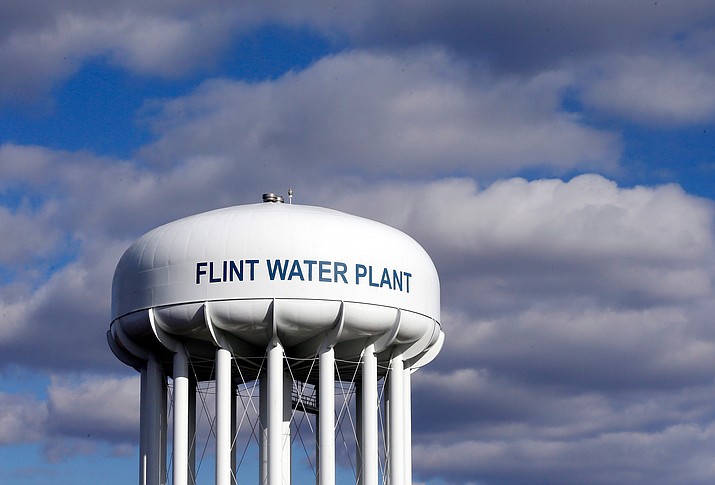 In this March 21, 2016 file photo, the Flint Water Plant water tower is seen in Flint, Mich. Prosecutors dropped all criminal charges Thursday, June 13, 2019, against eight people in the Flint water scandal and pledged to start the investigation from scratch. The defendants include Michigan's former health director, Nick Lyon, who was charged with involuntary manslaughter. He was accused of failing to timely alert the public about an outbreak of Legionnaires' disease that occurred in 2014-15 when Flint was drawing improperly treated water from the Flint River. (Carlos Osorio/AP, File)