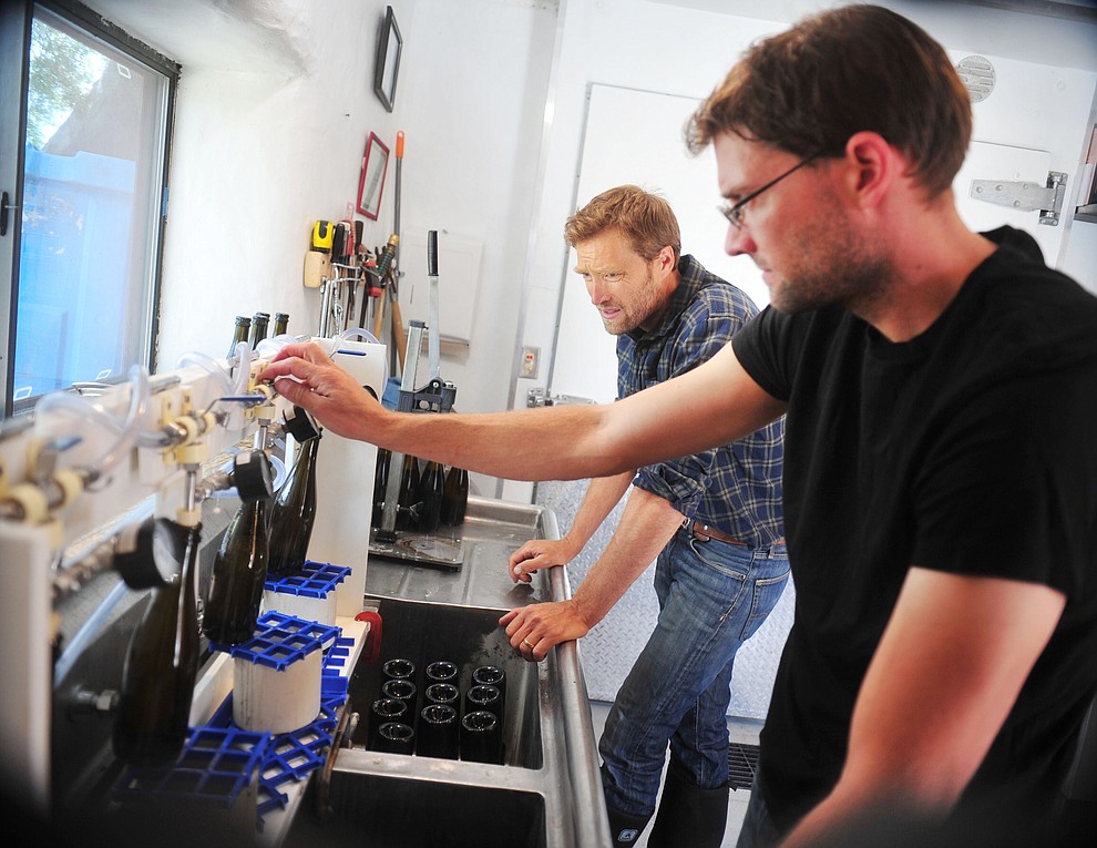 Cody and Kanin Tieney bottle some of their hard cider at the Stoic Cider orchard and bottling facility Tuesday, May 29 in Williamson Valley northwest of Prescott. (Les Stukenberg/Courier)