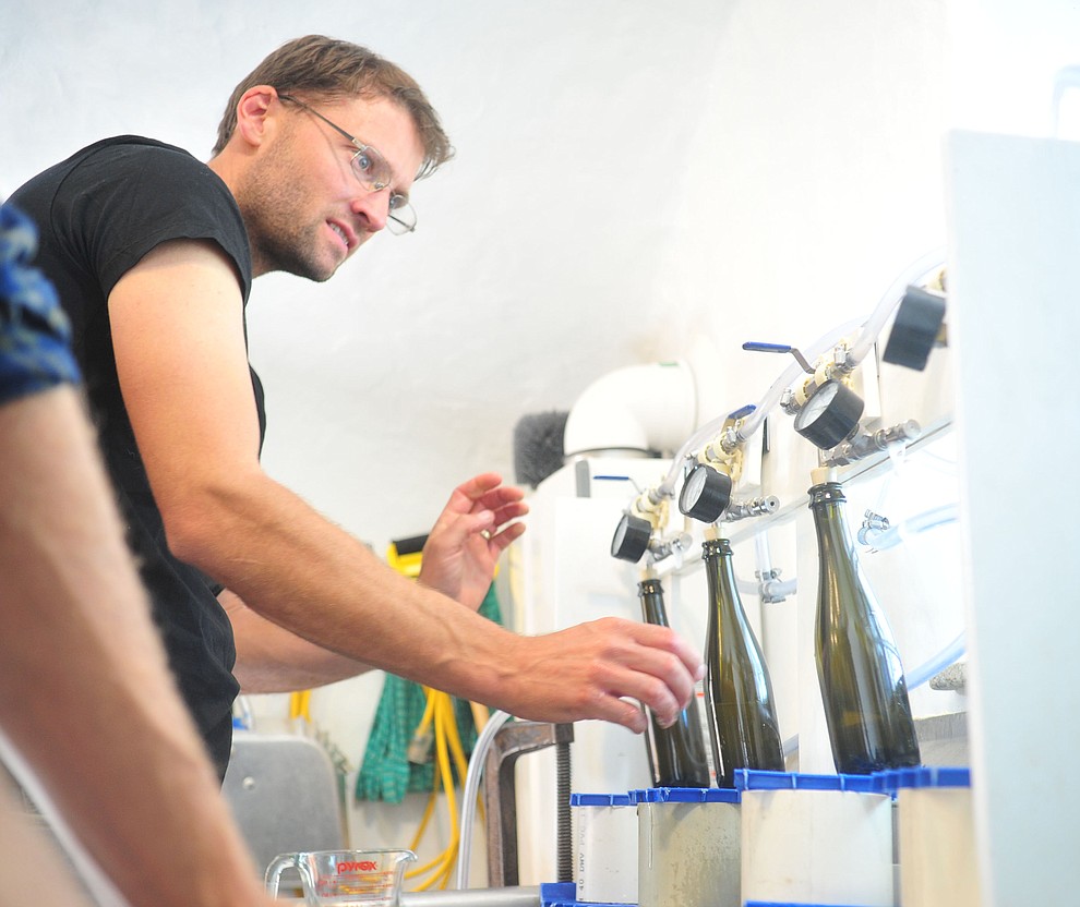 Cody Routson fills bottles at the Stoic Cider orchard and bottling facility Tuesday, May 29 in Williamson Valley northwest of Prescott. (Les Stukenberg/Courier)