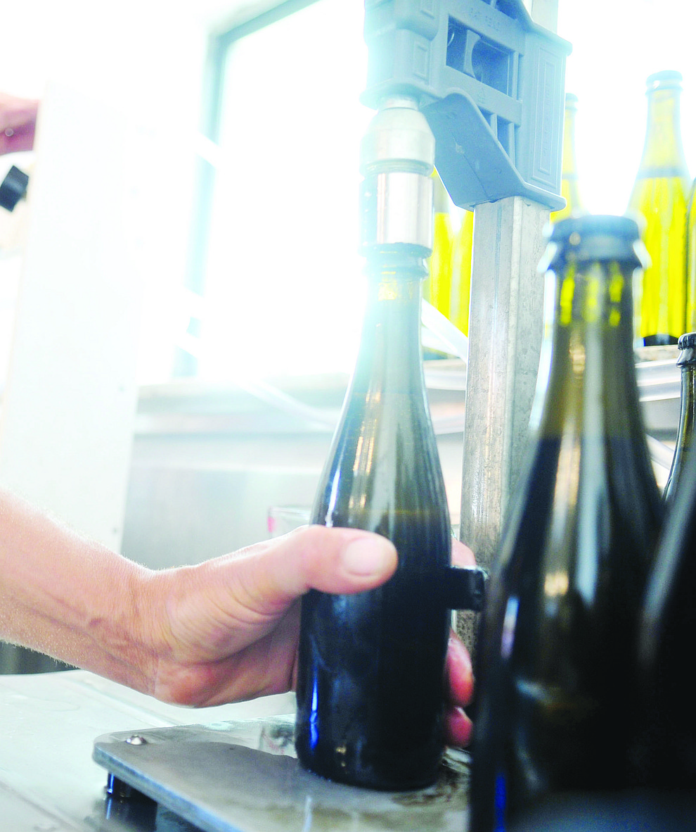 Kanin Routson caps the bottle at the Stoic Cider orchard and bottling facility Tuesday, May 29 in Williamson Valley northwest of Prescott. (Les Stukenberg/Courier)