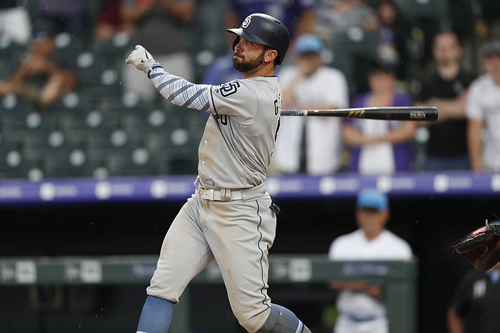 San Diego Padres’ Greg Garcia follows the flight of his triple to drive in two runs off Colorado Rockies relief pitcher Wade Davis in the ninth inning of a game Sunday, June 16, 2019, in Denver. (David Zalubowski/AP)