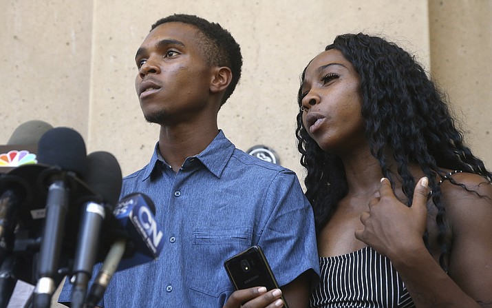 Iesha Harper, right, answers a question during a news conference as she is joined by her fiancée Dravon Ames, left, at Phoenix City Hall, Monday, June 17, 2019, in Phoenix. Ames and his pregnant fiancé, Harper, who had guns aimed at them by Phoenix police during a response to a shoplifting report, say they don't accept the apologies of the city's police chief and mayor and want the officers involved to be fired.(Ross D. Franklin/AP)