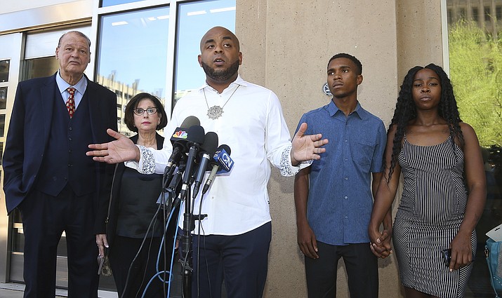 Rev. Jarrett Maupin, center, a civil rights advocate, speaks during a news conference as Dravon Ames, second from right, and Iesha Harper, right, are joined by their attorneys Sandra Slaton, second from left, and Tom Horne, left, at Phoenix City Hall, Monday, June 17, 2019, in Phoenix. Ames and his pregnant fianc e, Harper, who had guns aimed at them by Phoenix police during a response to a shoplifting report say they don't accept the apologies of the city's police chief and mayor and want the officers involved to be fired. (Ross D. Franklin/AP)