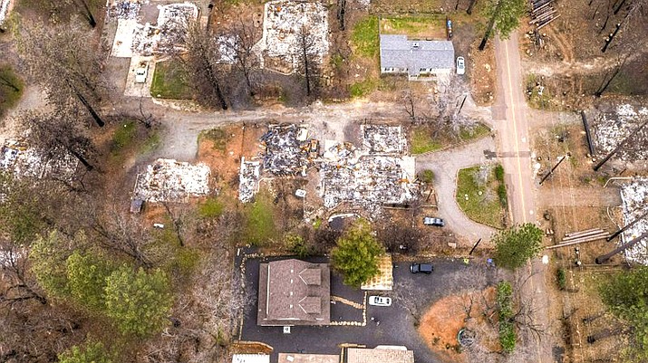 In this March 19, 2019 photo, an aerial image shows the home of Sean and Dawn Herr, bottom center, in Paradise, Calif. The Herr home, built in 2010 to new fire-resistant building standards, survived the fire while nearby homes burned. (Hector America/The Sacramento Bee via AP)
