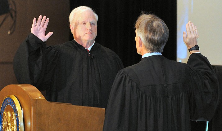 New Supreme Court Chief Justice Robert Brutinel is sworn in Friday by predecessor Scott Bales. (Capitol Media Services photo by Howard Fischer)