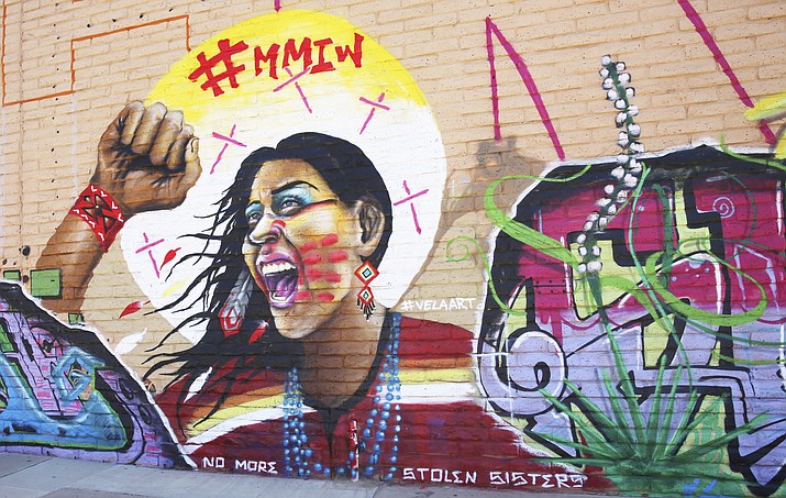 An indigenous woman takes center stage in a mural by artist Sebastian “Vela” Velazquez, erected on the Cruces Creatives building wall in Las Cruces, New Mexico. The #MMIW hashtag atop stands for Missing and Murdered Indigenous Women. ((Sebastian “Vela” Velazquez/The Las Cruces Sun News via AP)