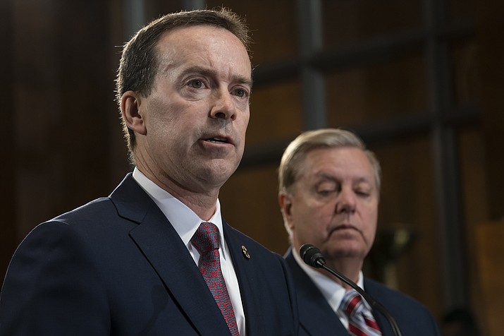 In this May 15, 2019, file photo, acting U.S. Customs and Border Protection Commissioner John Sanders, left, joins Senate Judiciary Committee Chairman Lindsey Graham, R-S.C., right, on Capitol Hill in Washington. Sanders says he's stepping down amid outrage over his agency's treatment of detained migrant children and said in a message to CBP employees Tuesday that he would resign on July 5. (J. Scott Applewhite/AP)