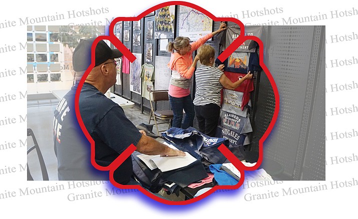 Volunteer Bob Tallet, left, works to prepare T-shirts for display, as fellow volunteers Debra Rocha, center, and Donna Beno attach shirts to the wall of the Granite Mountain Interagency Hotshot Crew Learning and Tribute Center at the Prescott Gateway Mall. The shirts from fire departments from around the world were placed on the memorial fence that surrounded the fire station of the Granite Mountain Hotshots, 19 of whom died fighting the Yarnell Hill Fire on June 30, 2013. (Cindy Barks/Courier)