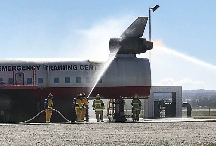 Grand Canyon Airport fire personnel practice suppressing a fire on a model airplane. Although most fires on the model are controlled by computer, fires can break out on their own, adding a sense of realism to the exercise.  (Photo/ADOT)