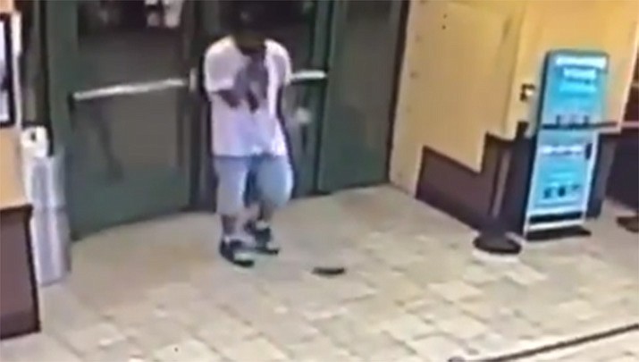 Police say three officers were at the shop in Coney Island, Brooklyn while on-duty Saturday when Emmanuel Lovett walked in, tugged his denim shorts and dropped a pistol to the floor. (NYPD Transit)