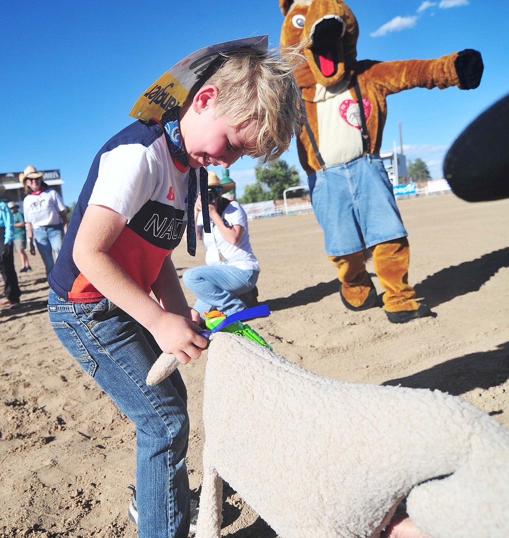 Seven-year old Isaiah Effenbeck unties the ribbon from the goat during the annual Happy Hearts Rodeo for Exceptional Children at the Prescott Frontier Days Rodeo Monday July 1, 2019.  (Les Stukenberg/Courier)