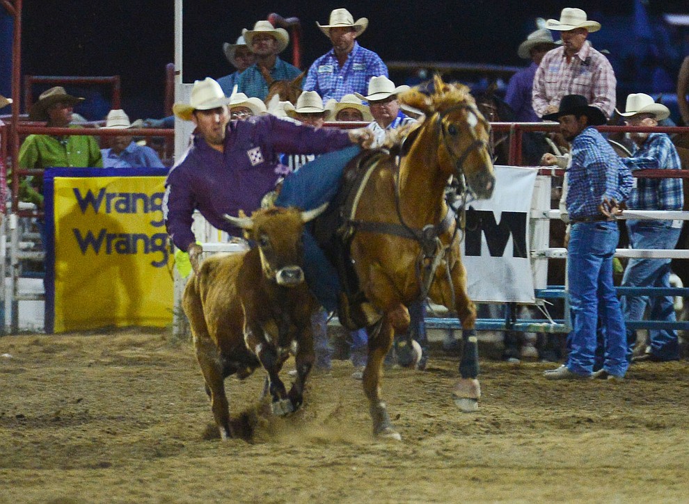 Riley Duval settles in for a 5.8 second run in the steer wrestling during the third performance of the Prescott Frontier Days Rodeo Wednesday July 3, 2019. (Les Stukenberg/Courier)