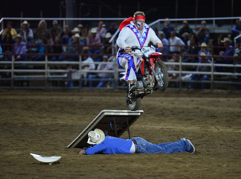 Rodeo Clown Justin Rumford makes a motorcycle jump during the third performance of the Prescott Frontier Days Rodeo Wednesday July 3, 2019. (Les Stukenberg/Courier)