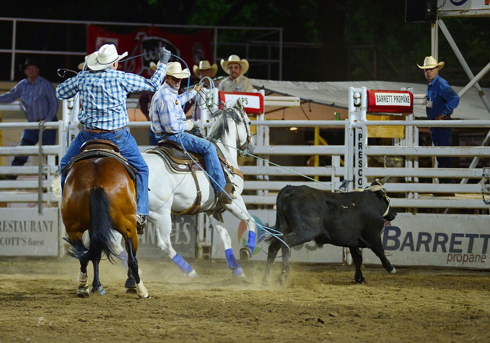 Travis Bard and Clinton Teller make an 8.9 second run in the team roping during the third performance of the Prescott Frontier Days Rodeo Wednesday July 3, 2019. (Les Stukenberg/Courier)