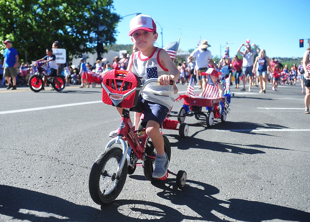 Children on bikes, scooters and in wagons ride during the 78th annual Kiwanis Kiddie Parade along Cortez Street in downtown Prescott Friday July 5, 2019. (Les Stukenberg/Courier)