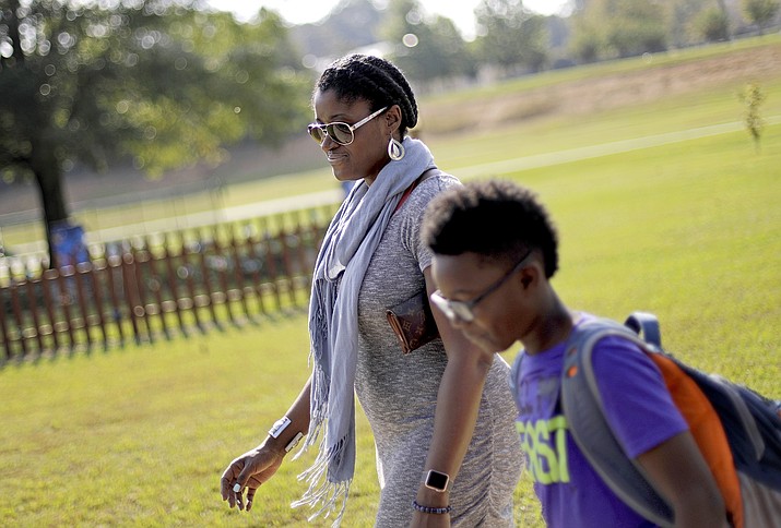 Corrie Davis, left, picks up her son Turner from Big Shanty Elementary School in Kennesaw, Ga., on Oct. 11, 2017. The previous month, the school invited fifth-graders to dress up as characters from the Civil War. Davis says a white student dressed as a plantation owner approached her son and said "You are my slave." She requested that the school to stop the annual Civil War dress-up day. (David Goldman/AP, File)