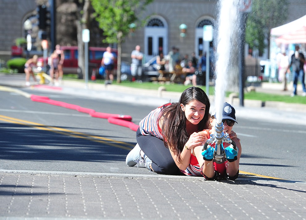 A team of wives and girlfriends of firefighters compete during the annual Hose Cart Races Sunday July 7, 2019 on Cortez Street in Prescott. The event has a history from the earliest days of the Prescott Fire Department when it was manned by volunteers. In the current version the competition has been going on for at least 70 years. (Les Stukenberg/Courier)