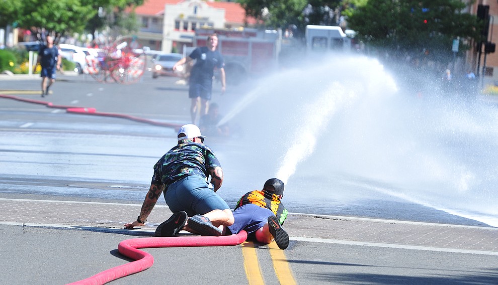 Trying to knock the cone over with a stream of water during the annual Hose Cart Races Sunday July 7, 2019 on Cortez Street in Prescott. The event has a history from the earliest days of the Prescott Fire Department when it was manned by volunteers. In the current version the competition has been going on for at least 70 years. (Les Stukenberg/Courier)