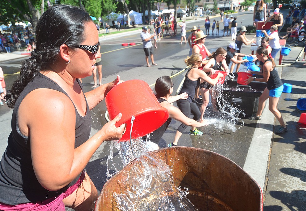 A team of wives and girlfriends of firefighters compete in the bucket brigade during the annual Hose Cart Races Sunday July 7, 2019 on Cortez Street in Prescott. The event has a history from the earliest days of the Prescott Fire Department when it was manned by volunteers. In the current version the competition has been going on for at least 70 years. (Les Stukenberg/Courier)