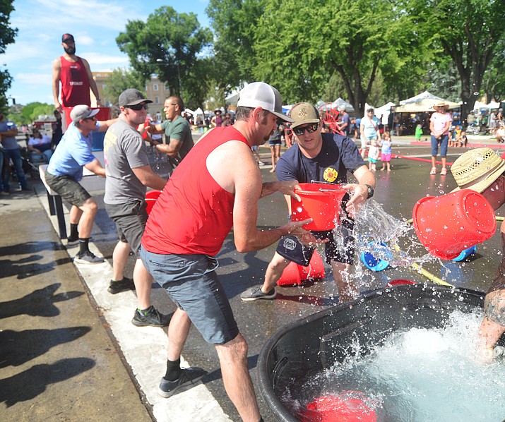 A team of Prescott firefighters compete in the bucket brigade during the annual Hose Cart Races Sunday July 7, 2019 on Cortez Street in Prescott. The event has a history from the earliest days of the Prescott Fire Department when it was manned by volunteers. In the current version the competition has been going on for at least 70 years. (Les Stukenberg/Courier)