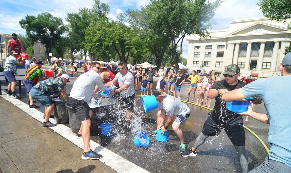It's Central Arizona Fire versus Peoria Fire in the bucket brigade during the annual Hose Cart Races Sunday July 7, 2019 on Cortez Street in Prescott. The event has a history from the earliest days of the Prescott Fire Department when it was manned by volunteers. In the current version the competition has been going on for at least 70 years. (Les Stukenberg/Courier)