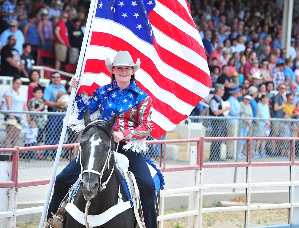 Sami Kilduff brings in the American Flag during the final performance of the Prescott Frontier Days Rodeo Sunday July 7, 2019. (Les Stukenberg/Courier)