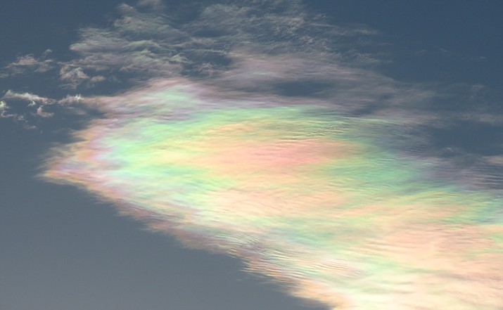 Noctilucent clouds glow in iridescent colors at sunset.