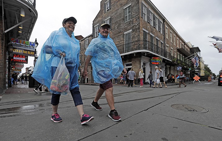 Alan and Dot Richardson, from England, wear ponchos as they walk along Bourbon Street in the French Quarter Friday, July 12, 2019, in New Orleans, ahead of Tropical Storm Barry. (David J. Phillip/AP)