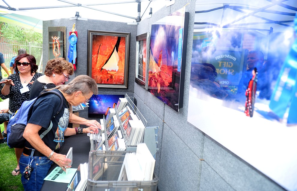 Customers browse Priscilla Tacheny's artistic photographs at the Prescott Indian Arts Market at the Sharlot Hall Museum Saturday July 13, 2019. For a short video of the event go to dCourier.com..The show continues Sunday. (Les Stukenberg/Courier)