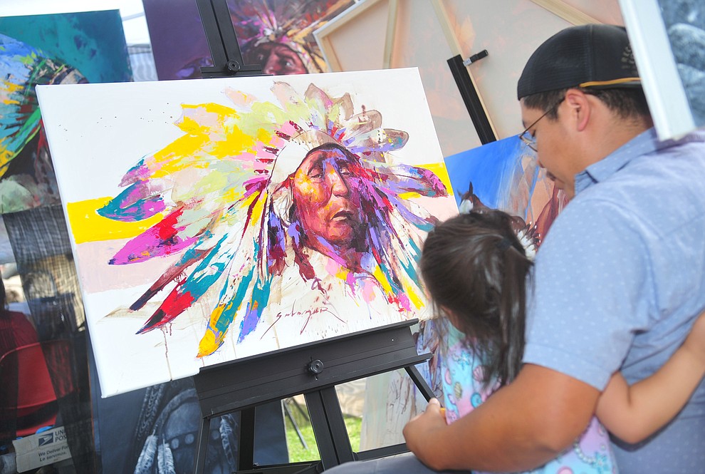 Navajo painter Jeremy Salazar looks at his most recent piece at the Prescott Indian Arts Market at the Sharlot Hall Museum Saturday July 13, 2019. For a short video of the event go to dCourier.com..The show continues Sunday. (Les Stukenberg/Courier)