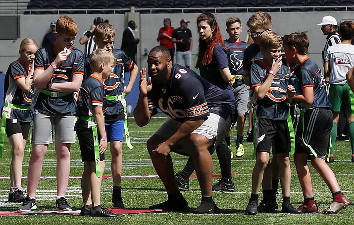 NFL Player Akiem Hicks of the Chicago Bears coaches a young team during the final tournament for the UK's NFL Flag Championship, featuring qualifying teams from around the country, at the Tottenham Hotspur Stadium in London, Wednesday, July 3, 2019. The new stadium will host its first two NFL London Games later this year when the Chicago Bears face the Oakland Raiders and the Carolina Panthers take on the Tampa Bay Buccaneers. (Frank Augstein/AP)