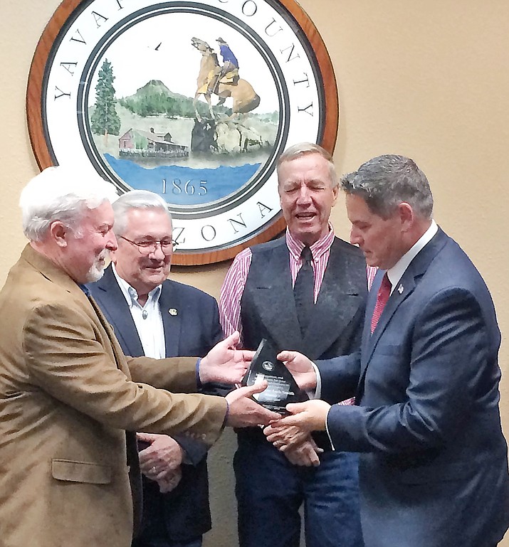 Board of Supervisors Chairman Randy Garrison, left, gives District 5 Supervisor Jack Smith, right, a plaque of recognition for his seven years’ service as Supervisors Craig Brown and Tom Thurman look on during the July 3, 2019, meeting of the board (Supervisor Rowle Simmons was absent). (Sue Tone/Tribune)