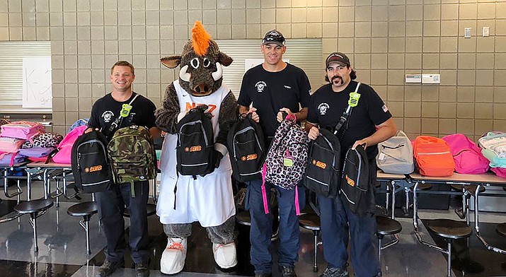 Pictured from the 2018 HUSD backpack event are firefighters from Central Arizona Fire and the NAZ Suns Mascot, “Buckets,” who helped hand out backpacks to students. (HUSD/Courtesy)