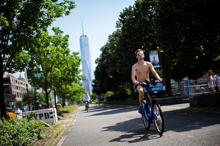 Cyclists ride down a path near the Hudson River during high temperatures on Saturday, July 20, 2019 in New York. Temperatures in the high 90s are forecast for Saturday and Sunday with a heat index well over 100. Much of the nation is also dealing with high heat. One World Trade Center is seen in the background. (Eduardo Munoz Alvarez/AP)