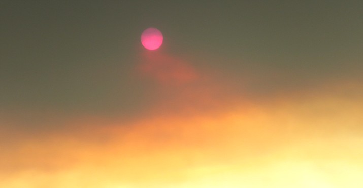 A cherry-red sun shines through smoke. Melissa Bowersock