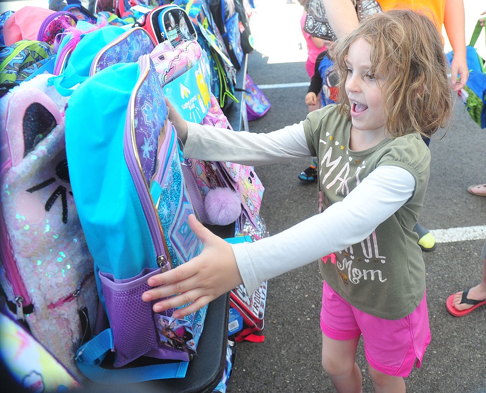 Prescott Valley's Aaliyah Payne finds her Frozen backpack as the Yavapai Food Bank gave away 1300 backpacks in the parking lot of Findlay Toyota Center Saturday July 27, 2019 in Prescott Valley. (Les Stukenberg/Courier)