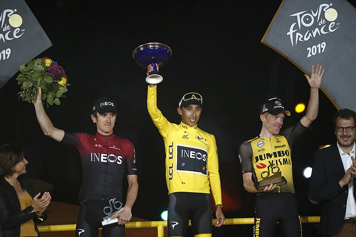 Colombia's Egan Bernal, the winner, center, Britain's Geraint Thomas, who placed second, left, and the Netherlands' Steven Kruijswijk, third, stand on the podium of the Tour de France cycling race in Paris, France, Sunday, July 28, 2019. (Michel Euler/AP)