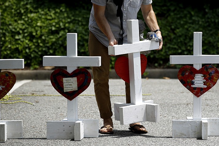 A volunteer prepares to place crosses June 2, 2019, for victims of a mass shooting at a municipal building in Virginia Beach, Va., at a nearby makeshift memorial. The U.S. has recorded nearly 20 mass killings so far this year, including the one in Virginia Beach, the majority of them domestic violence massacres that receive scant national attention compared to high-profile public shootings at schools, churches and concerts in recent years. (Patrick Semansky/AP, File)
