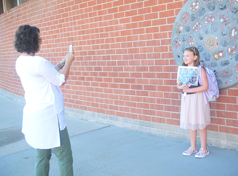 Dee Olson takes a picture of third grader Ellie Olson for the first day of school at Taylor Hicks Elementary School in Prescott Thursday, August 1, 2019. (Les Stukenberg/Courier)