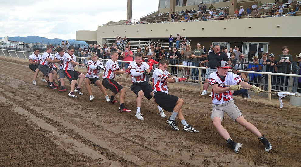 Bradshaw Mountain High School football players pull hard as they take on the jockeys from Arizona Downs in a tug-a-war Saturday, August 3, 2019, in on the racetrack in Prescott Valley. (Les Stukenberg/Courier)