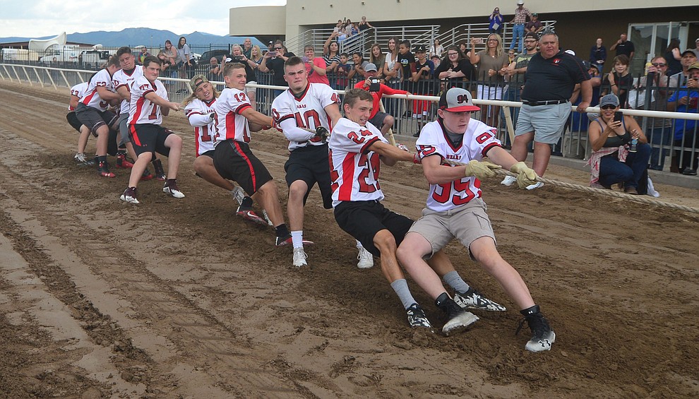 Bradshaw Mountain High School football players pull hard as they take on the jockeys from Arizona Downs in a tug-a-war Saturday, August 3, 2019, in on the racetrack in Prescott Valley. (Les Stukenberg/Courier)