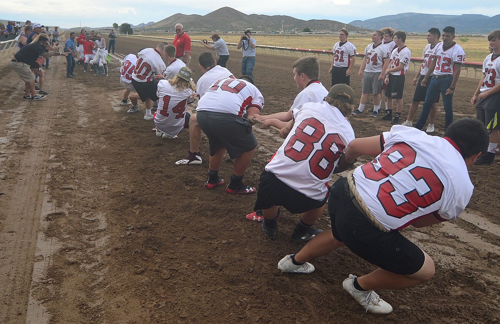 Bradshaw Mountain High School football players pull hard as they take on the jockeys from Arizona Downs in a tug-a-war Saturday, August 3, 2019, in on the racetrack in Prescott Valley. (Les Stukenberg/Courier)