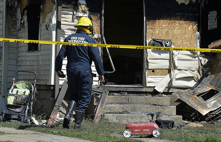 Erie Bureau of Fire Inspector Mark Polanski helps investigate a fatal fire at 1248 West 11th St. in Erie, Pa, on Sunday, Aug. 11, 2019. Authorities say an early morning fire in northwestern Pennsylvania claimed the lives of multiple children and sent another person to the hospital. (Greg Wohlford/Erie Times-News via AP)