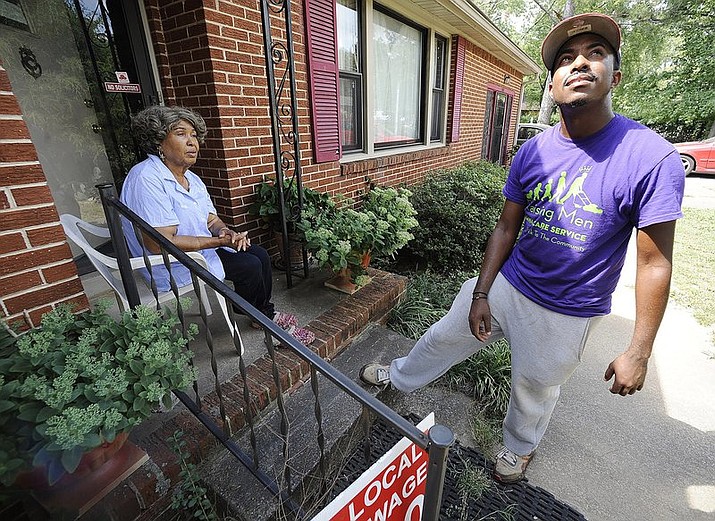 In this Saturday, Sept. 10, 2016 file photo, Rodney Smith Jr., founder of Raising Men Lawn Care Service, looks skyward while talking with homeowner Irene Renee Jolly in Huntsville, Ala. Smith Jr., who traveled to all 50 states to mow lawns for free says he’s traveling across the country again to bring together police officers and the community. Rodney Smith Jr. tweeted Monday, August 12, 2019 to announce his tour called “Mowing with Cops” will start Wednesday August 14 in Apopka, Florida. (AP Photo/Jay Reeves, File)