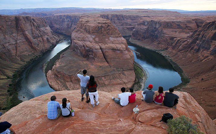 In this Sept. 9, 2011 file photo visitors view the dramatic bend in the Colorado River at the popular Horseshoe Bend in Glen Canyon National Recreation Area, in Page, Ariz. Some 40 million people in Arizona, California, Colorado, Nevada, New Mexico, Utah and Wyoming draw from the Colorado River and its tributaries. Much of that originates as snow. A wet winter likely will fend off mandated water shortages for states in the U.S. West that rely on the river but won't erase the impact of climate change. Climate change means the region is still getting drier and hotter. (AP Photo/Ross D. Franklin, File)