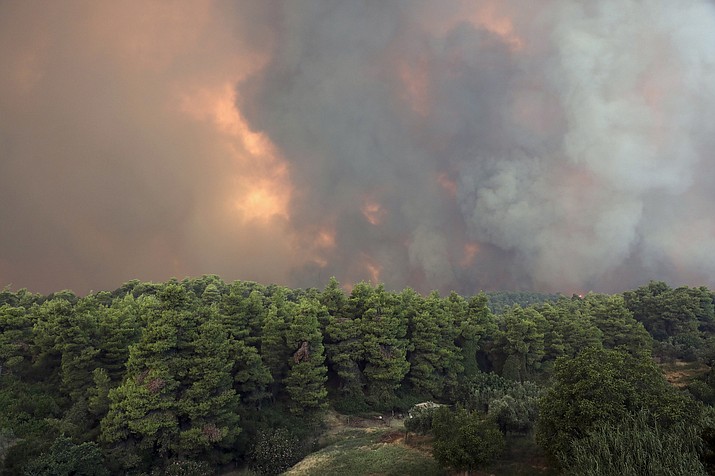 A huge cloud of smoke rise from a forest fire at Psachna village on the island of Evia, northeast of Athens, Tuesday, Aug. 13, 2019. Dozens of firefighters backed by water-dropping aircraft are battling a wildfire on an island north of Athens that has left the Greek capital blanketed in smoke. (AP Photo/Yorgos Karahalis)